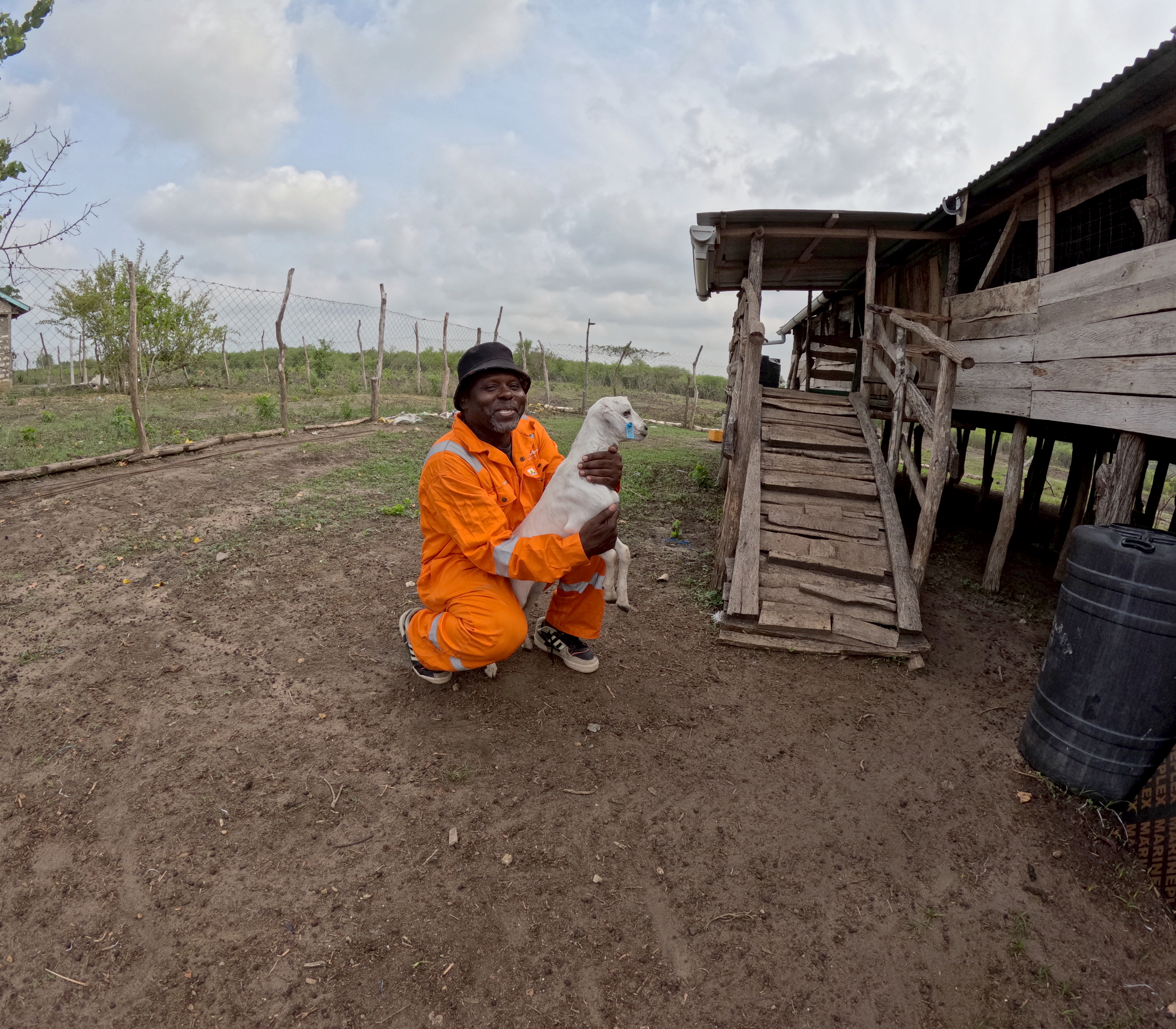 Zakaria smiling while holding a white goat during the health check